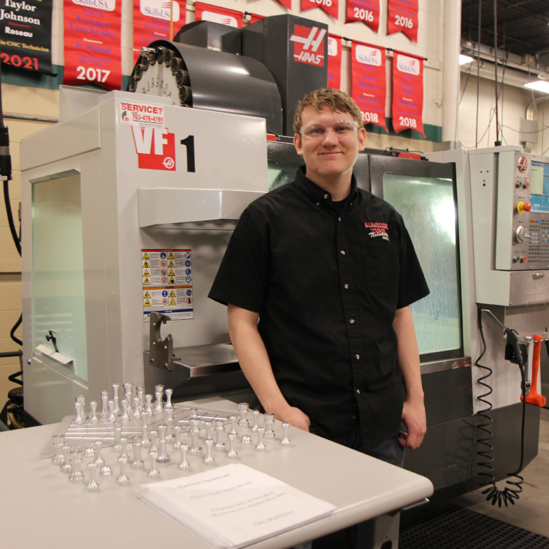 Machine tool student stands next to project